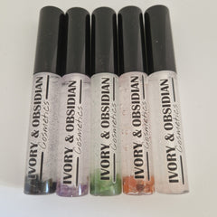 Lip gloss tubes with black caps, clear liquid, and "IVORY & OBSIDIAN Cosmetics" text