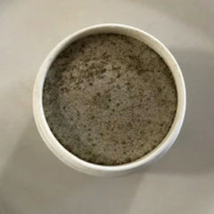 White ceramic bowl with grey speckled contents, top-down view