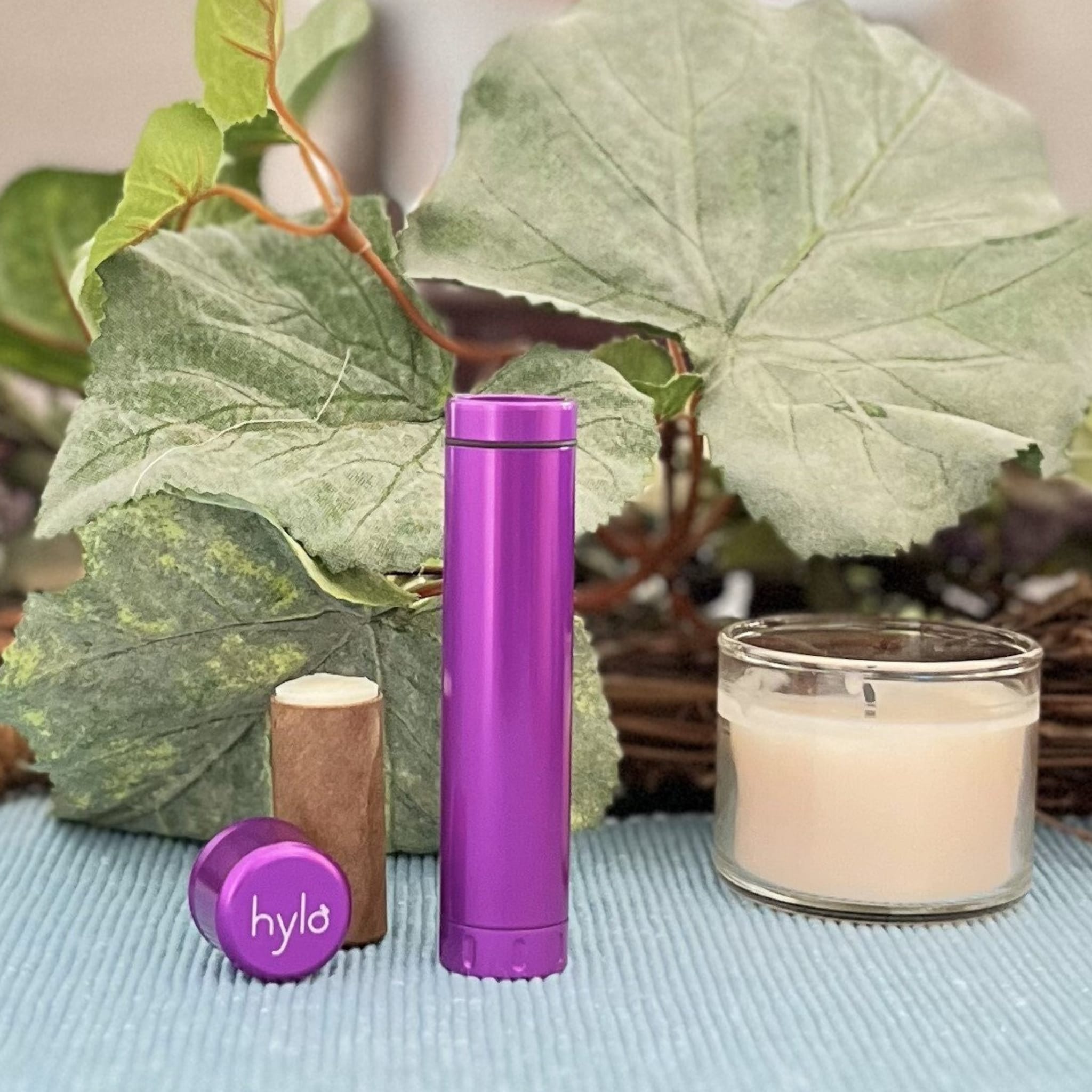 Lip balm, purple aluminum tube and cap with Hylo logo, with lip balm stick and candle