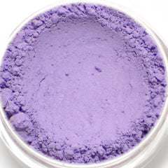 Powdered purple pigment in a clear container, showing a fine, powdery texture and a light lavender hue