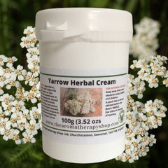 Close-up of creamy white yarrow herbal cream in a sleek jar with gold accents, showcasing its rich texture