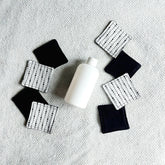 Makeup remover pads, black and white fabric with moon pattern, with white bottle on white towel