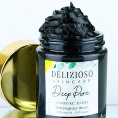 Black charcoal cleansing balm in sleek jar with gold lid, shown open to reveal rich dark texture