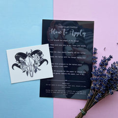 Temporary tattoo with black and white ram skull design on white paper, with instructions card