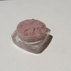 Close-up of loose matte brown mineral eyeshadow with fine mica shimmer in eco-friendly packaging