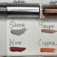 Makeup swatches in silver, taupe, wine, and copper colors on white background