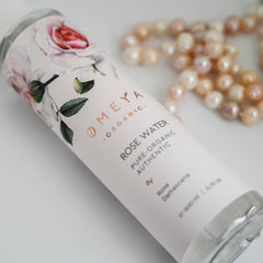 Rose water bottle with floral design, white label, and "Meya Organic" branding