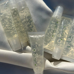 Aloe vera lip gloss, clear gel tubes, white caps, Planet Khalia branding visible