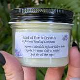 Tallow balm jar with black lid, clear glass, and Heart of Earth Crystals label