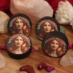 Lip balm in black container with Aphrodite's Lip Balm text and floral design, Merakii brand visible