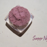Close-up of loose mineral eye shadow powder in pale mauve shade with soft shimmer finish