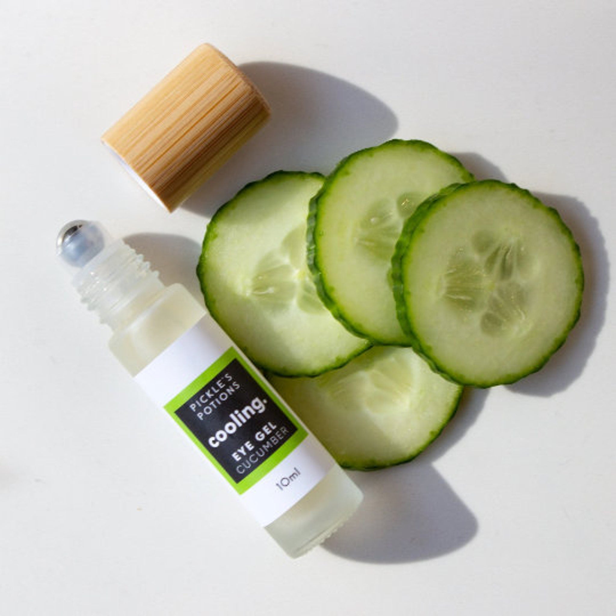 Eye makeup cooling gel with clear bottle, stainless rollerball, and cucumber slices
