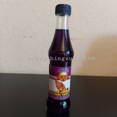 Facial oil bottle with purple liquid, clear glass, and Indlovu label on black surface