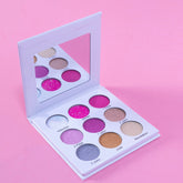 Eyeshadow palette with multiple colorful shades in white compact, open with mirror on pink background