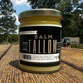 Tallow balm jar with gold lid and black label, on wood surface, Lady May brand
