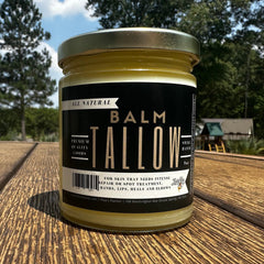Tallow balm jar with gold lid and black label, on wood surface, Lady May brand