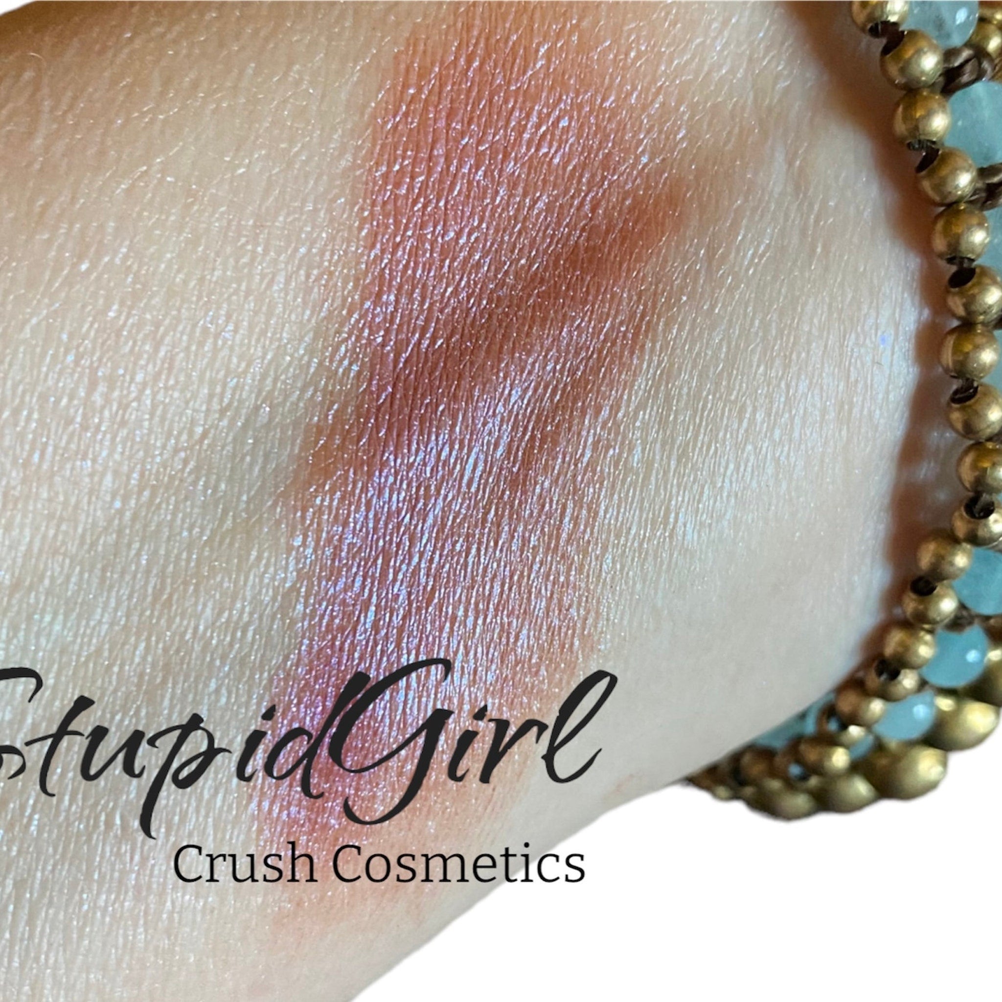 Eye makeup swatch with pink shimmer, skin texture visible, and Crush Cosmetics text