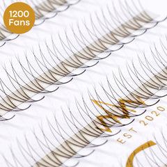 Eyelash extensions with black synthetic fibers on a white strip, "1200 Fans" label visible
