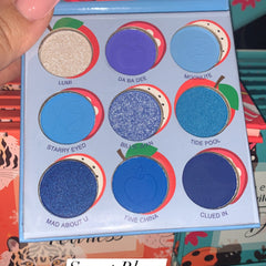 Close-up of hand applying shimmery peach eyeshadow with a fluffy brush onto eyelid