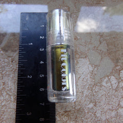 Close-up of shimmering handmade eyeshadow palette with rich burgundy and gold tones in compact case