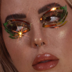 Eye makeup with green and gold accents, applied on eyes, close-up shot