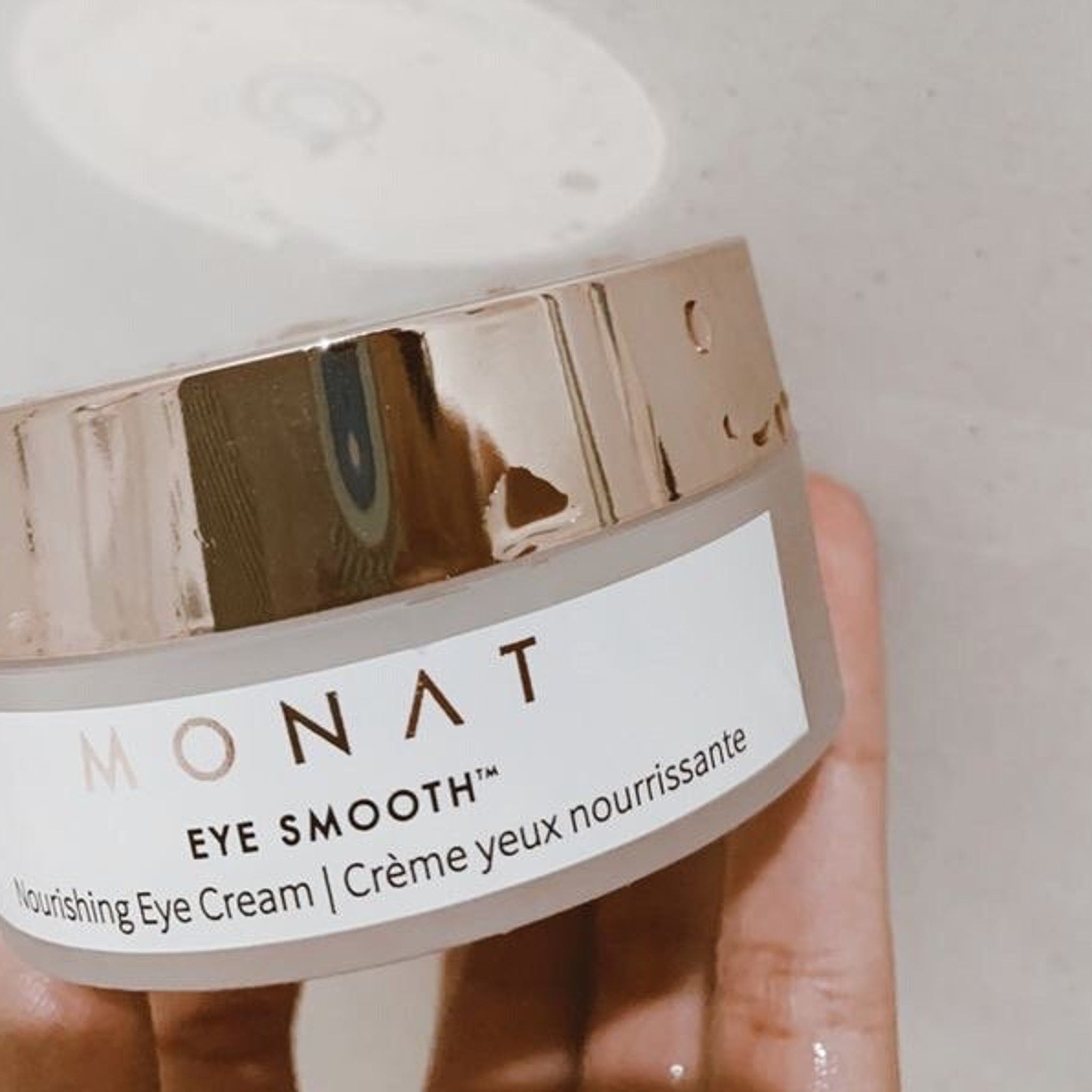Eye cream jar with rose gold lid, white label, and Monat branding