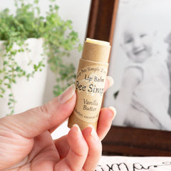 Lip balm tube with brown paper, yellow balm, and Bee Simple label held in hand