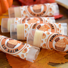 Pumpkin lip balm tubes with orange and white labels, clear plastic, and pumpkin illustrations