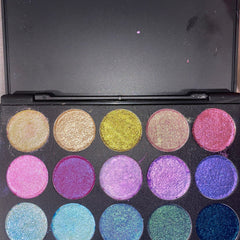 Side view of 9-pan eyeshadow palette displaying matte and shimmer shades in warm neutrals and bold jewel tones