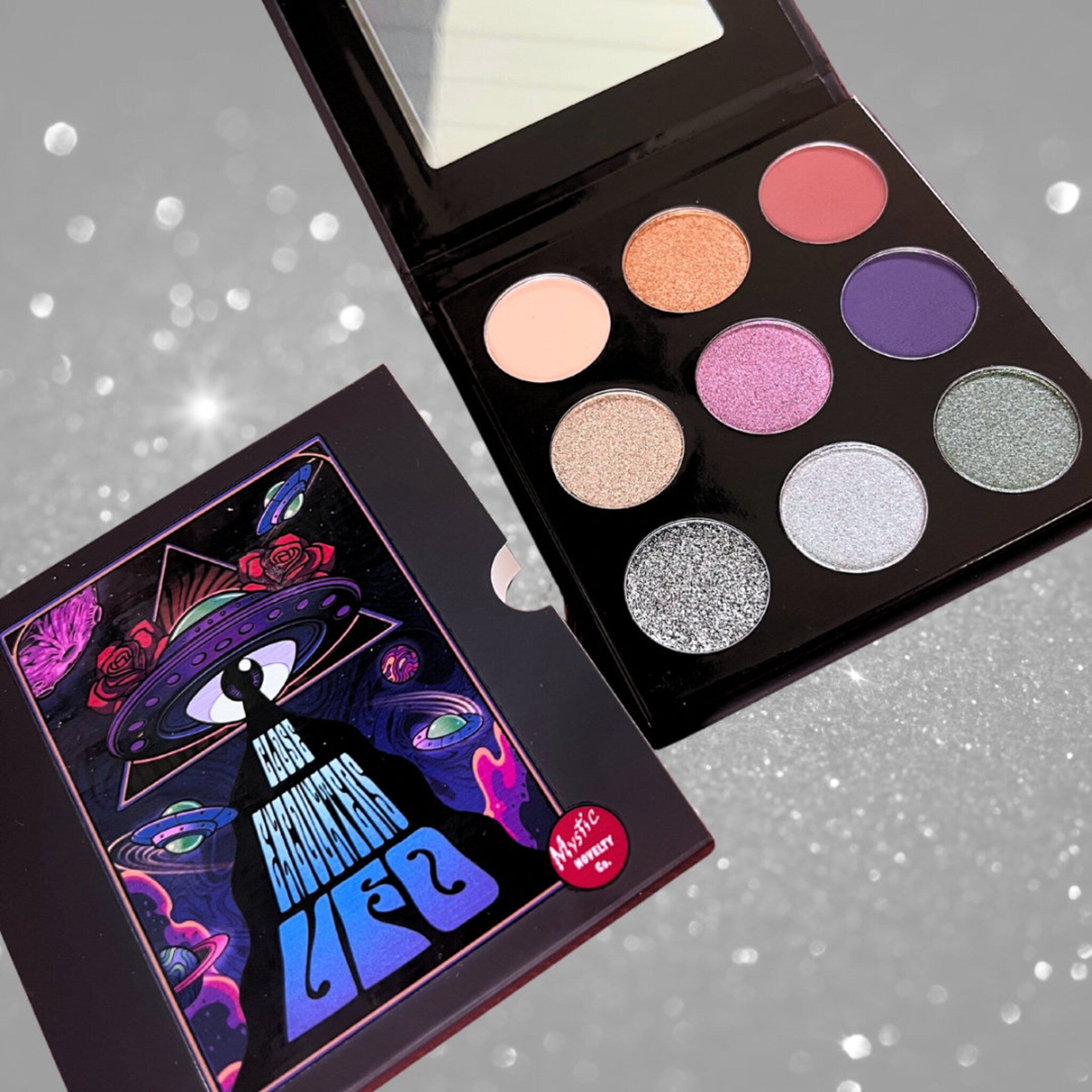 Eyeshadow palette with colorful eyeshadows, black case, and Mystic Novelty branding