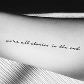 Three minimalist temporary tattoo sheets with delicate script designs for skincare routines, laid flat on marble surface