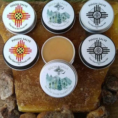 Skin care Piñon Salve in white metal tins with graphic design and brand text on top