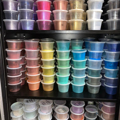 Close-up of nine vibrant eyeshadow pans showing matte and shimmer textures in a sleek black palette