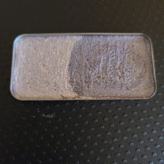 Side view of multichrome eyeshadow palette showing iridescent shift from teal to purple in compact case