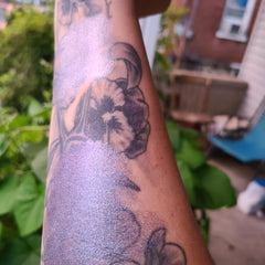 Close-up of multichrome eyeshadow palette showing iridescent shift from emerald green to deep violet