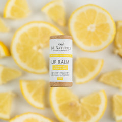 Lip balm tube with JNL Naturals branding, brown cardboard, and white label, surrounded by yellow lemon slices