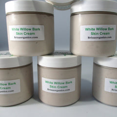 Skin cream jars with white lids, beige cream, and Brinaorganics labels, stacked together