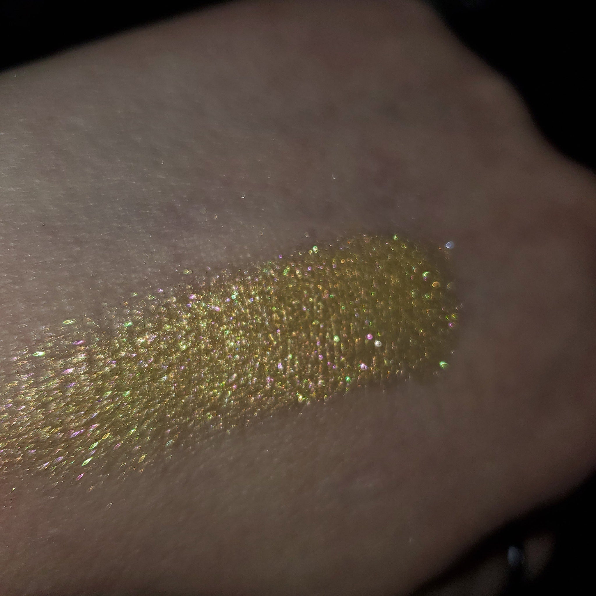 Eye shadow swatch, gold glitter, iridescent shimmer, on skin