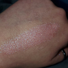 Close-up of shimmering bronze eye shadow palette with smooth, blendable powder texture