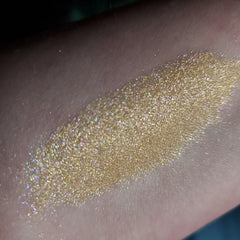 Glitter eyeshadow swatch in gold with iridescent shimmer on skin