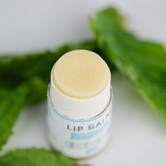 Lip balm with light yellow balm, white paper tube, and JNL Naturals text visible