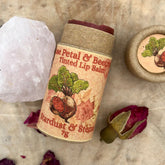 Lip balm in paper tube with dark red balm, Stardust & Stems label, and beet illustration