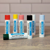 Goat Milk Lip Balm tubes with colorful caps, Blue Heron Farm branding, and flavor labels