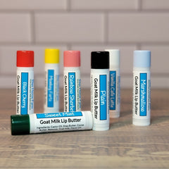 Goat Milk Lip Balm tubes with colorful caps, Blue Heron Farm branding, and flavor labels