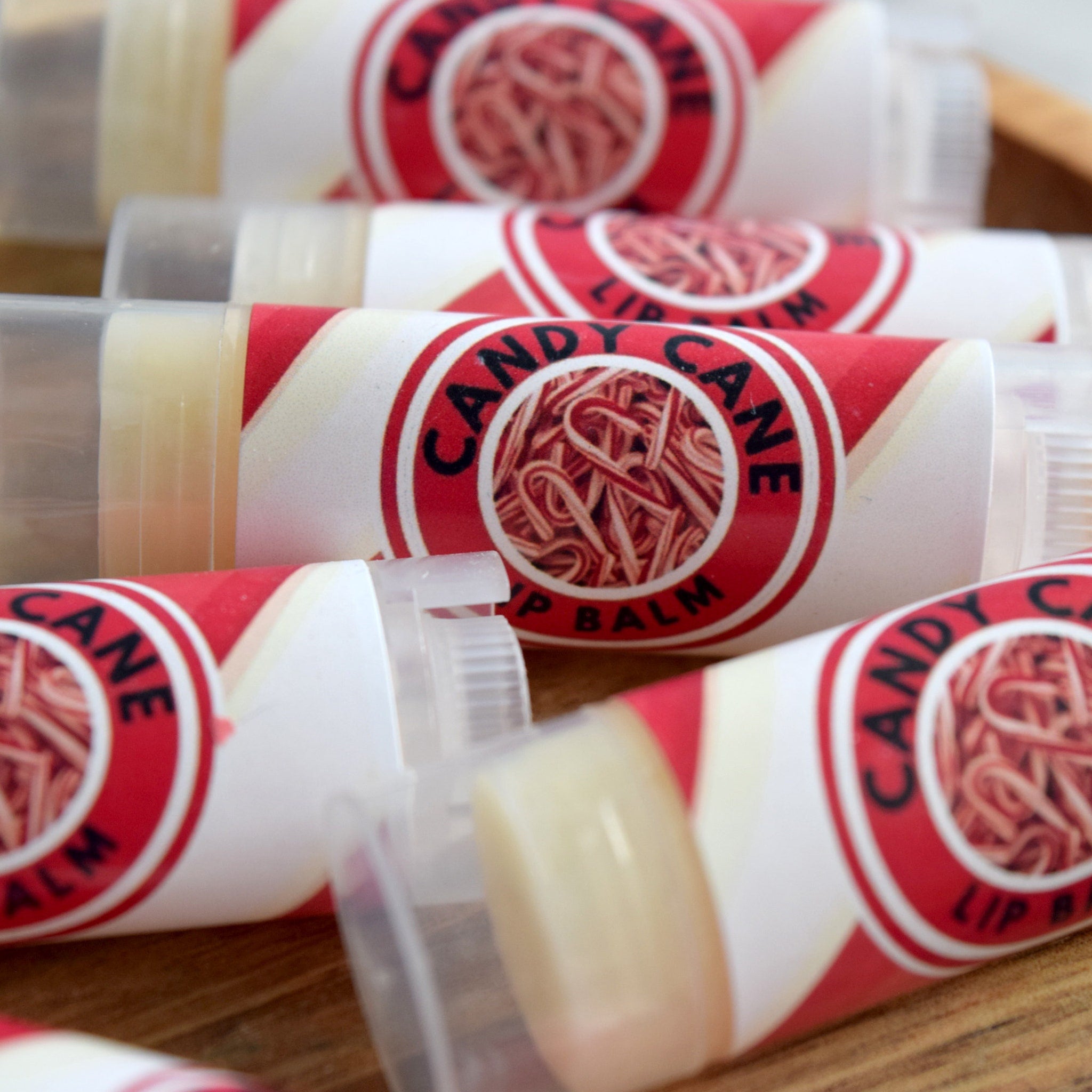 Lip balms with red and white labels, clear tubes, and candy cane pattern