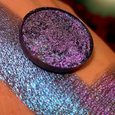 Eye shadow, purple glitter, round compact, swatch on skin