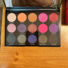 Eyeshadow palette with various colors and round pans in black compact