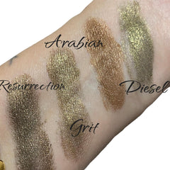 Eyeshadow swatches in gold, bronze and green metallic shades on skin, Diesel and Grit labels visible