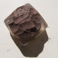 Close-up of rich dark brown vegan loose mineral eyeshadow with shimmer pigment, cruelty-free and finely milled texture