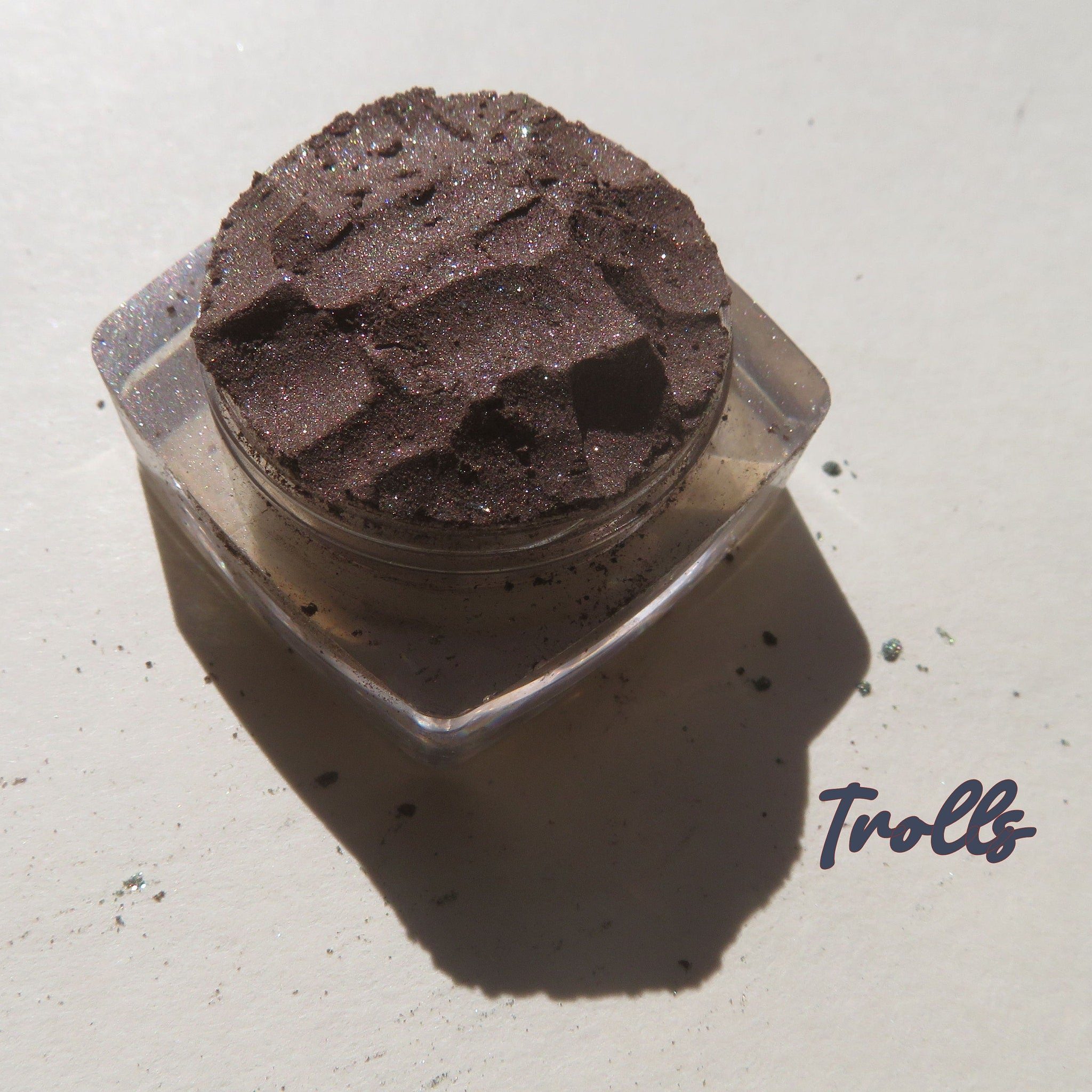 Rich dark brown vegan loose mineral eyeshadow with shimmer pigment in a small round jar, cruelty-free.